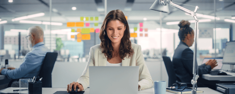 A corporate employee smiling while working with her team